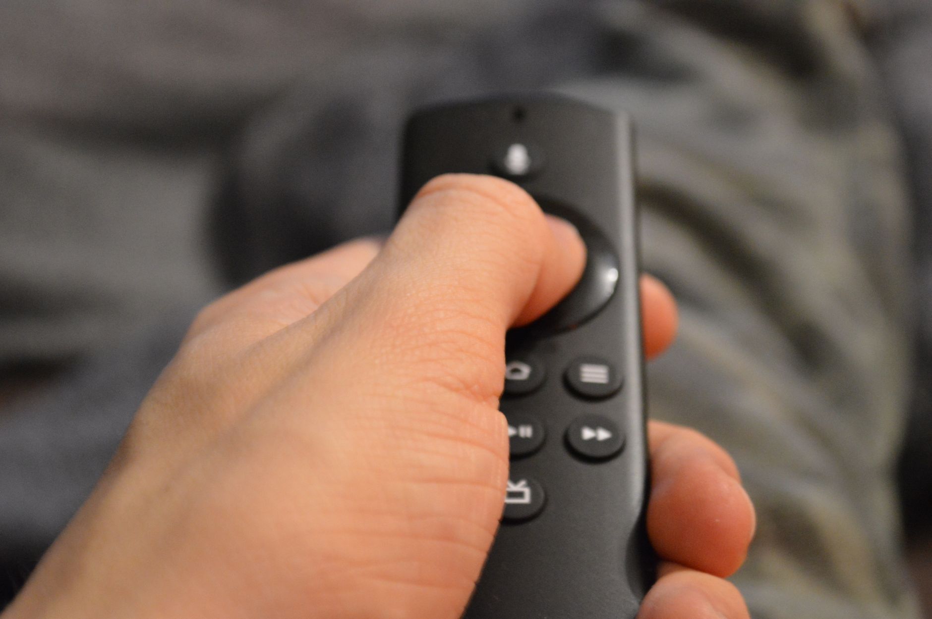 person holding black remote control in close up photography